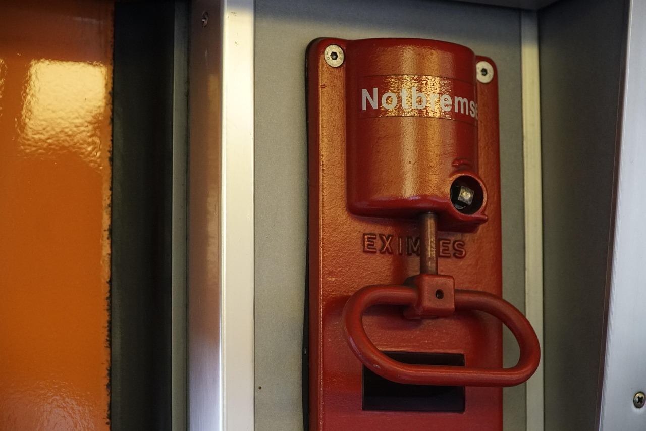 A red emergency brake handle mounted on the wall inside a train carriage, labelled Notbremse