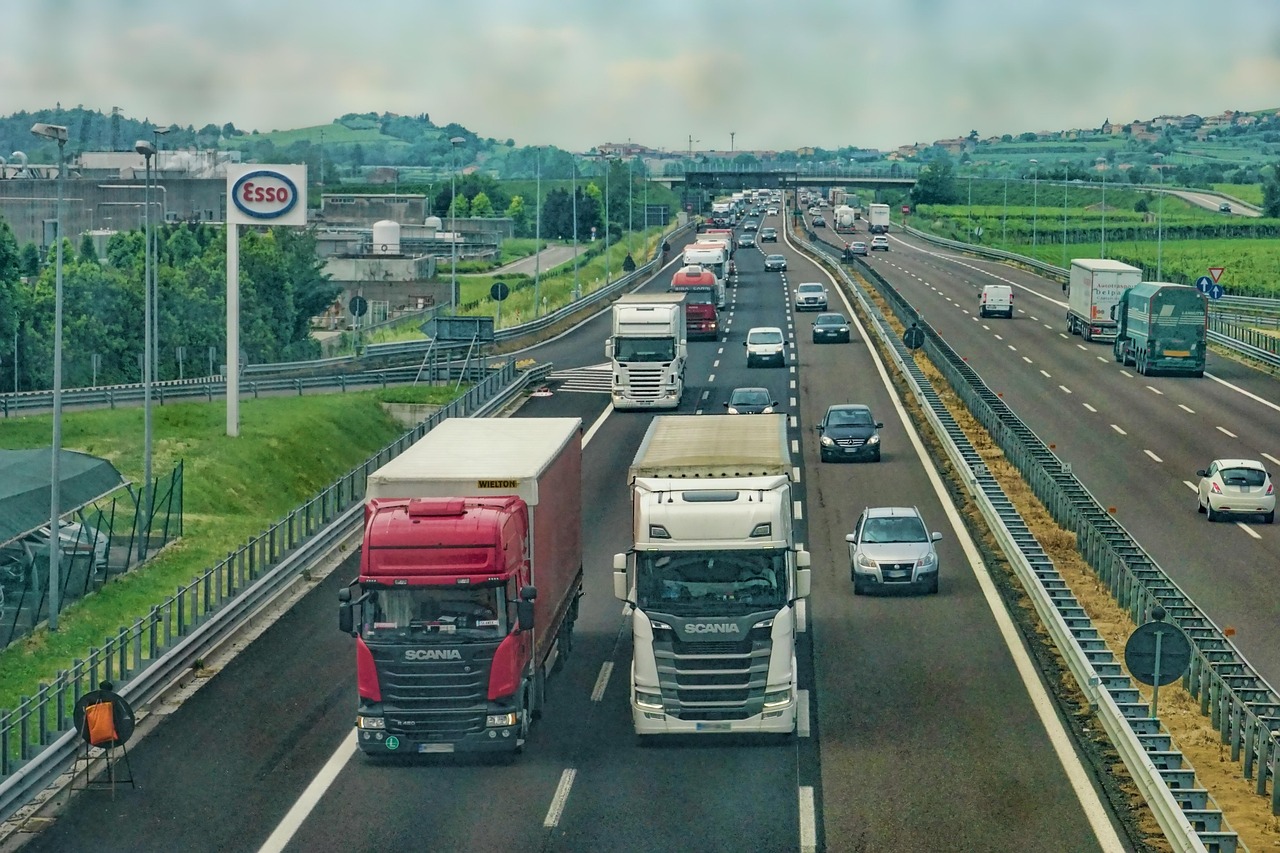 A multi-lane motorway with cars and trucks travelling side by side in parallel