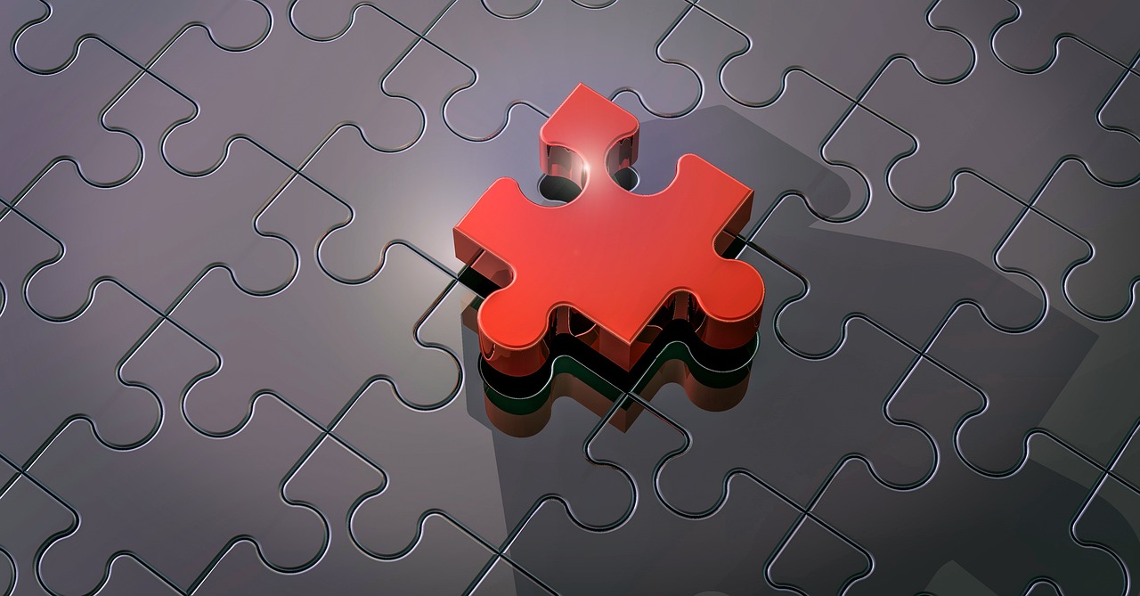 A red jigsaw piece slotting into the last gap of a grey puzzle