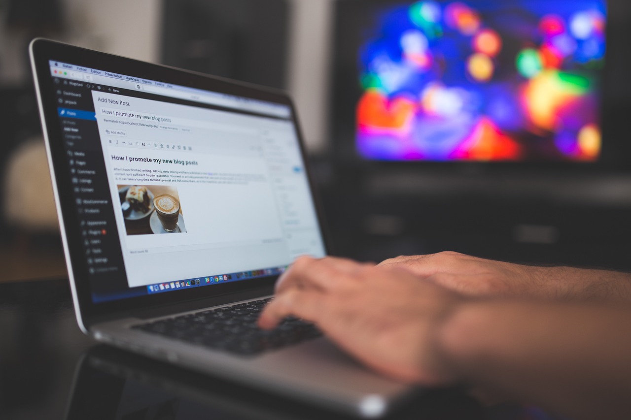 A person typing on a laptop showing the WordPress 'Add New Post' editor with a draft blog post