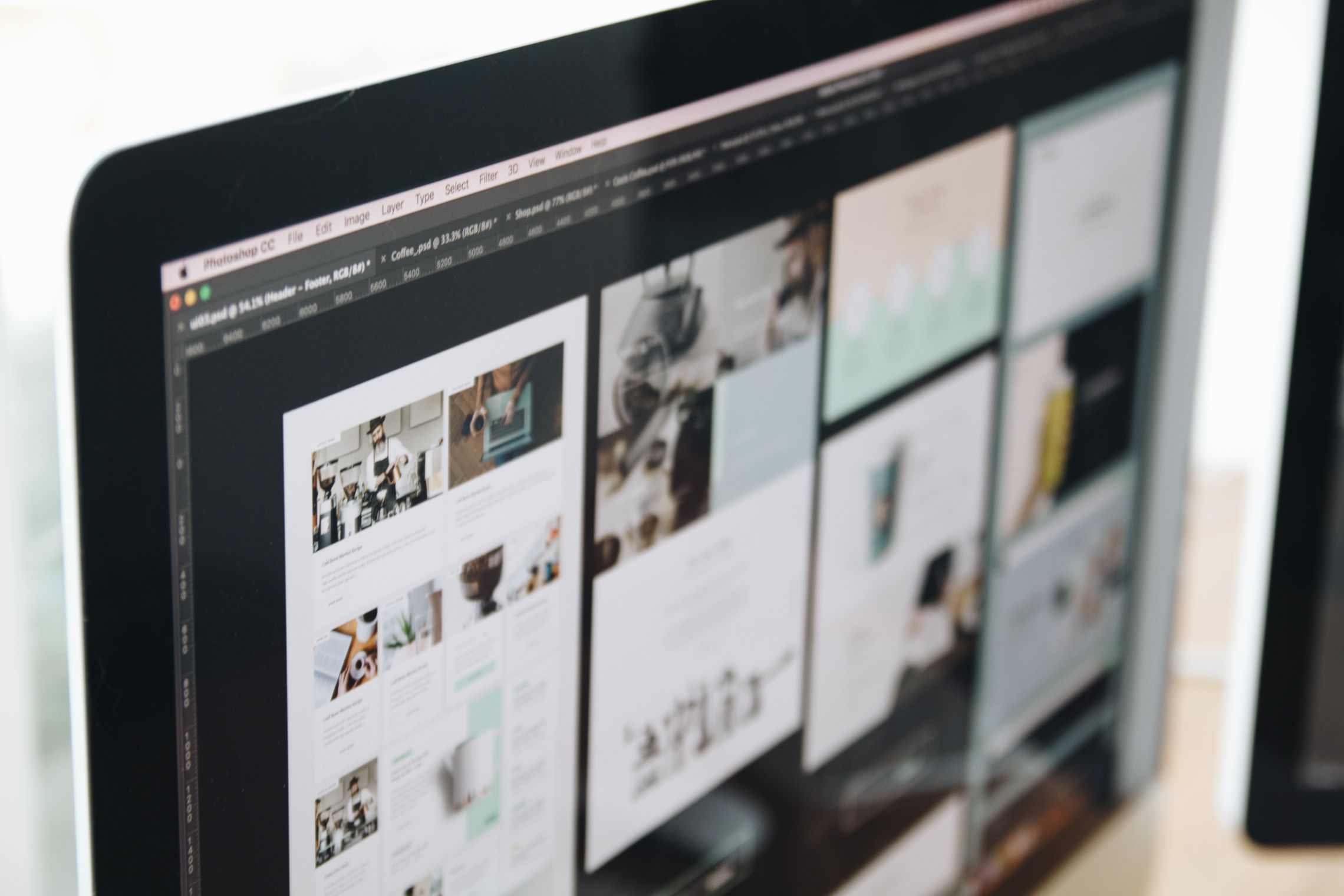 Web page layouts open in a design app on a computer monitor