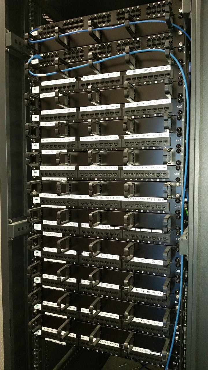 Ein voller Serverschrank mit Cat6-Patchpanels und blauen Ethernet-Kabeln, die an nummerierte Ports angeschlossen sind