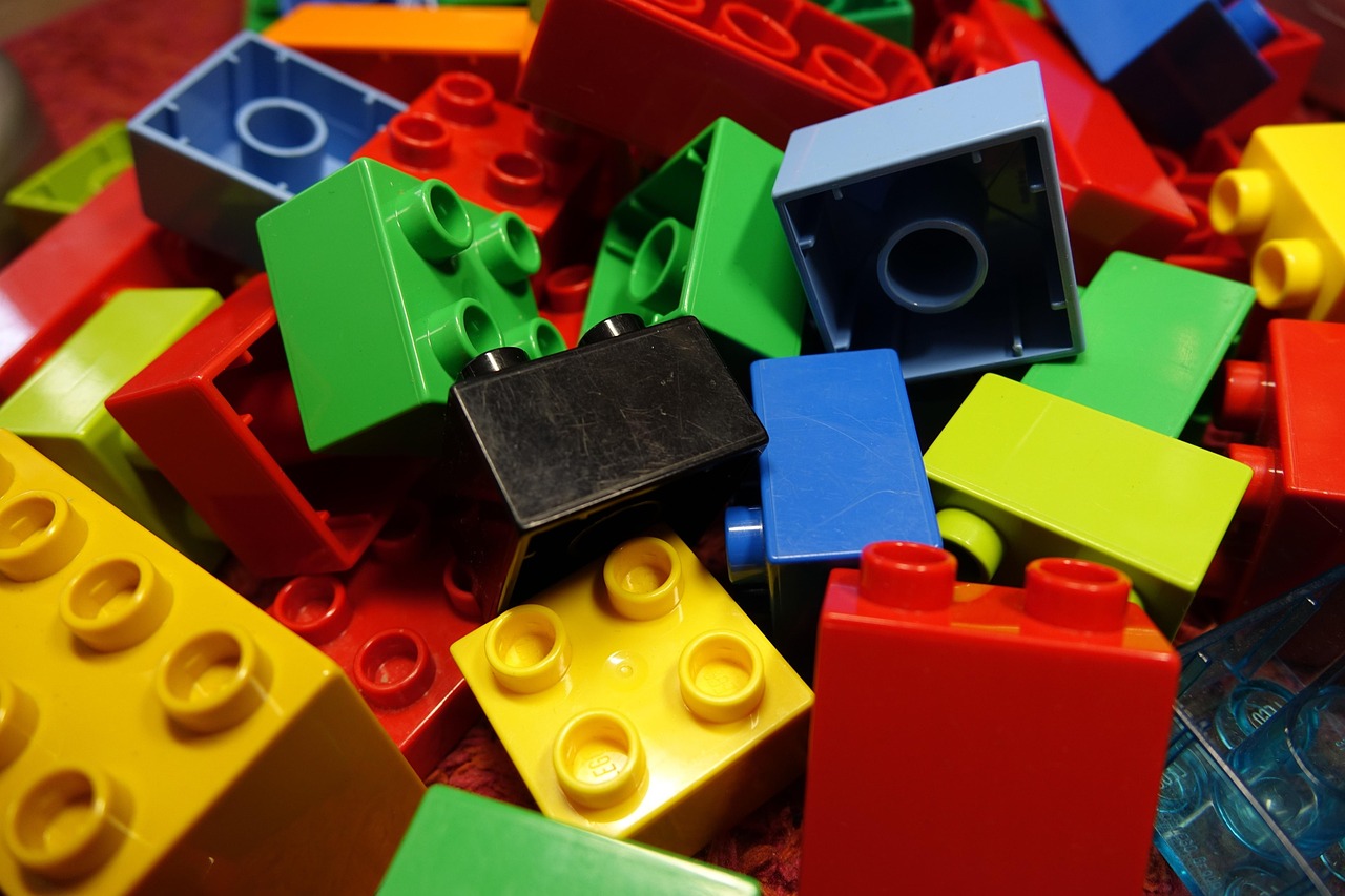 A pile of colourful interlocking plastic building blocks of different shapes